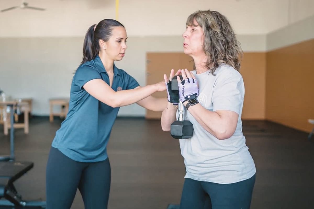 Coach guiding a client through an exercise at Align Pain & Performance